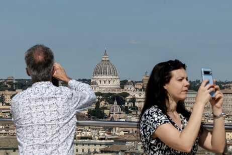 Turistas toman foto desde un punto elevado del centro romano.