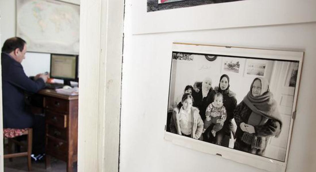 Foto di una delle prime famiglie migranti arrivate a Riace. Sullo sfondo Domenico Lucano al lavoro nell’ufficio dell’associazione “Città Futura”. © Gianfranco Ferraro © ANSA