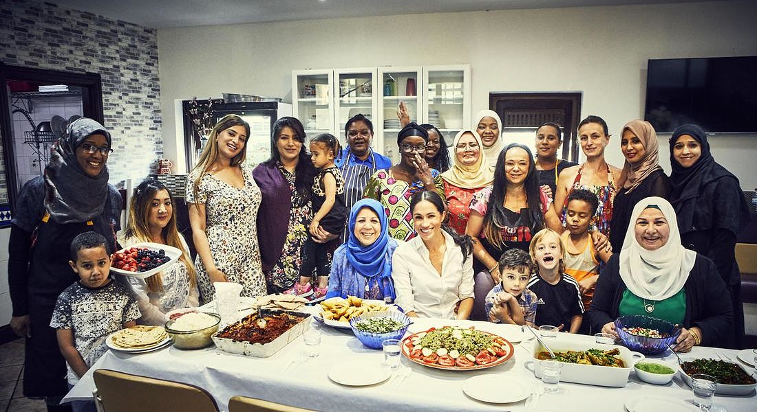 Meghan, la duchessa del Sussex, al centro, posa per una fotografia con le donne della Hubb Community Kitchen al Centro culturale musulmano Al Manaar di Londra. © AP