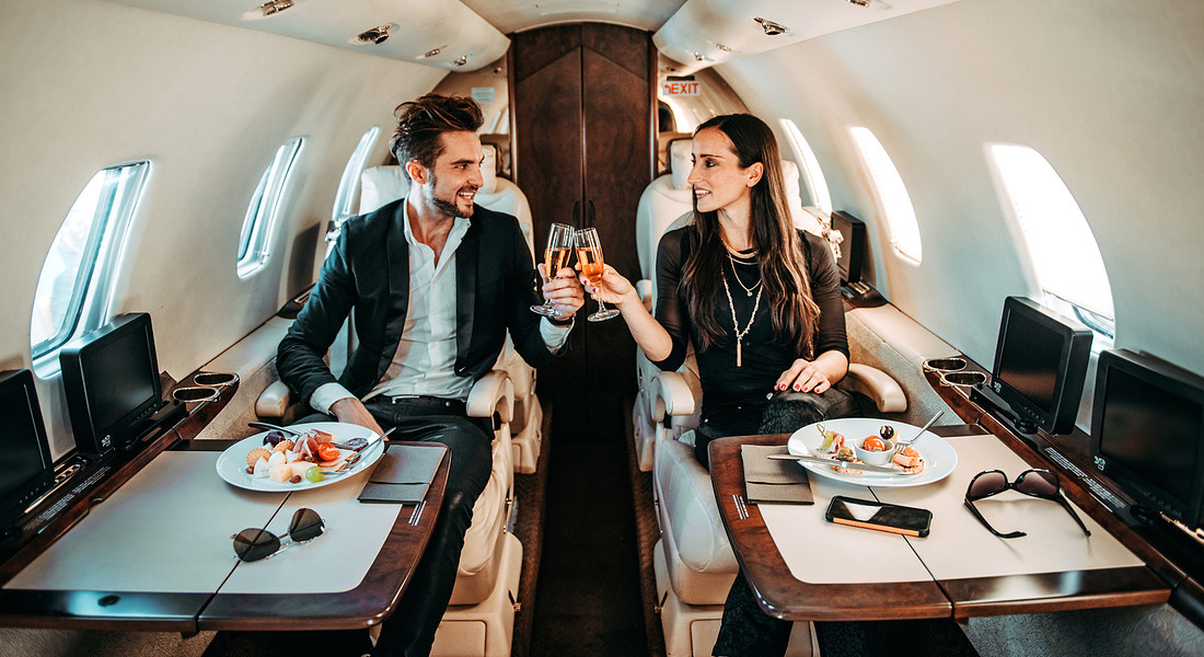 Una coppia nella cabina di un aereo beve champagne. foto iStock. © ANSA