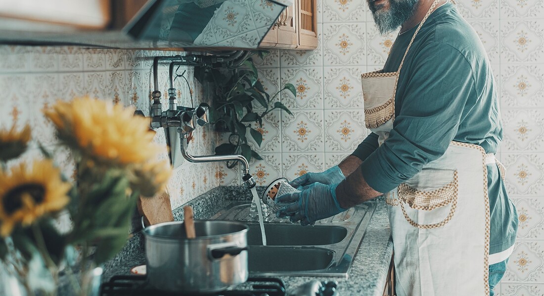 Un uomo lava i piatti foto iStock. © Ansa
