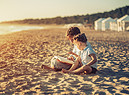 Al tramonto lettura di bambini sulla spiaggia foto iStock. (ANSA)