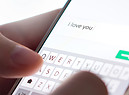 Una persona scrive Ti amo in un messaggio telefonico . foto iStock. (ANSA)