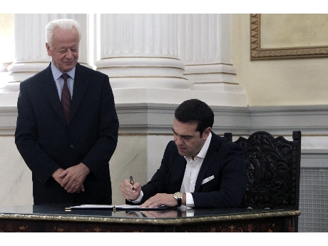 Alexis Tsipras, firma documentos tras asumir como Primer Ministro griego   (ANSA).
