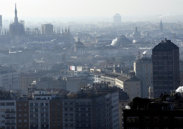 Fumo esce dai camini sui tetti nel centro di Milano, foto archivio © ANSA 