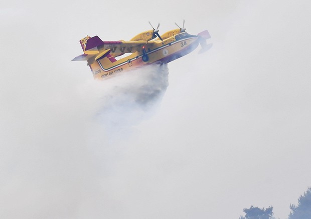 Un canadair in volo per l'emergenza incendi sulle montagne di Mompantero a Susa, sabato © ANSA