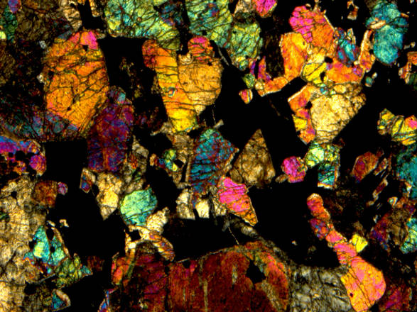 Immagine di una sezione dello spessore di 30 micrometri della meteorite marziana NWA 7387, realizzata con un microscopio polarizzante a 25 ingrandimenti. Sono visibili i cristalli di olivina (fonte: Museo di Scienze Planetarie della Provincia di Prato)