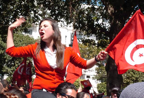 A Tunisian woman holds the national flag and shouts slogans during a demonstration in Tunis (archive)