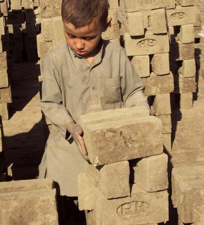 Un bimbo lavora in una fabbrica di mattoni vicino Kabul
