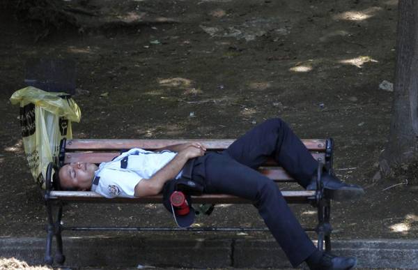 Un poliziotto esausto si riposa su una panchina di Gezy Park