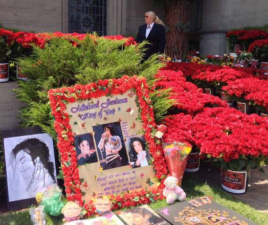 Immagini e fiori davanti al mausoleo di  Michael Jackson