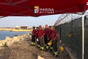 Vigili del fuoco si fanno segno croce davanti a relitto migranti
