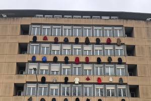 Cappotti appesi alle finestre del palazzo dell'Enea per la campagna ecobonus condomini (ANSA)