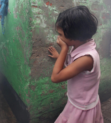 Una bambina si copre il volto con la mano in una foto d'archivio © ANSA 