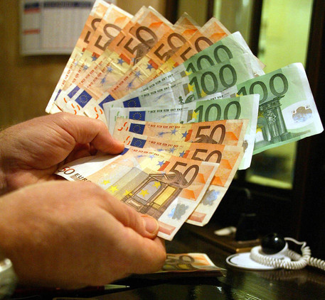 Un uomo tiene in mano alcune banconote di Euro in un'immagine di archivio © ANSA 