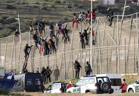 Migranti nel recente tentativo di scavalcare la recinzione a Melilla © EPA
