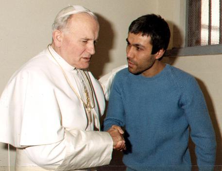 Giovanni Paolo II parla con il suo attentatore Mehmet Ali Agca nel carcere di Rebibbia in una foto del 1983 © ANSA