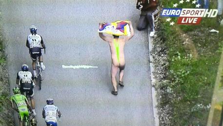 Nel fermo immagine dall'emittente Eurosport, un uomo nudo corre in salita al fianco dei ciclisti del Giro d'Italia (foto: ANSA)