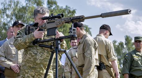 Il presidente ucraino, Petro Poroshenko, ispeziona un fucile di precisione delle forze armate di Kiev © ANSA 