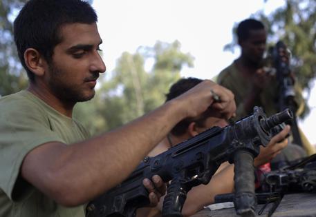 Un soldato israeliano ripulisce la propria arma © EPA