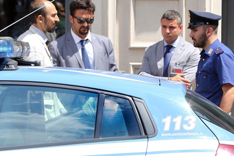L'uomo arrestato viene portato via dall'ispettorato di polizia della Camera a piazza del Parlamento dopo la rapina nella filiale del Banco di Napoli a Palazzo San Macuto, 5 agosto 2014 © ANSA