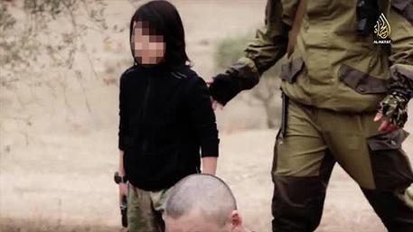 Un frame del nuovo video shock dell'Isis, nel quale un bambino spara ai prigionieri © ANSA