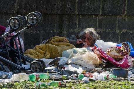 Una barbona stesa tra i rifiuti a Napoli © ANSA 