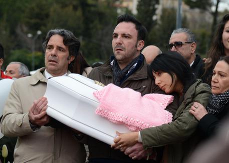 Neonata morta: padre porta in braccio bara fino a cimitero © ANSA