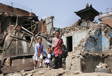 Una mamma con le sue figlie in mezzo alle macerie del terremoto a Kathmandu, Nepal © EPA