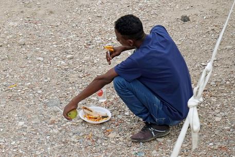 Un migrante ha ricevuto da mangiare © ANSA