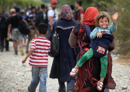 Rifugiati che attraversano il confine tra Macedonia e Grecia © EPA