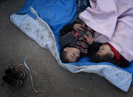 Bimbi profughi dormono nei pressi della città di Gevgelija in Macedonia © EPA