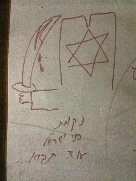 Le scritte minacciose in ebraico, con il disegno di una spada insanguinata, ritrovate sulla Chiesa della Dormizione a Gerusalemme © ANSA