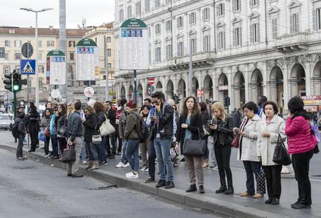 Una fila di persone in attesa di un autobus a Roma © ANSA