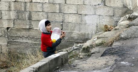 Bambino con una tanica di acqua a Damasco © ANSA 