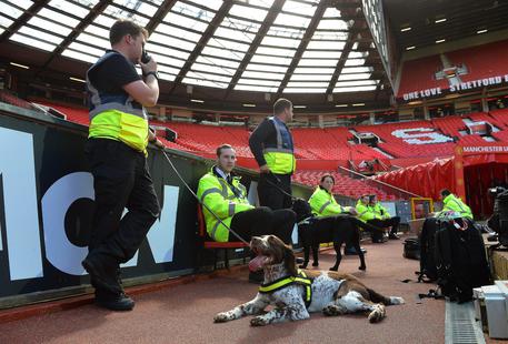 Agenti e cani-poliziotto sulle tribune dell'Old Trafford dopo che lo stadio e' stato evacuato a causa di una bomba © EPA
