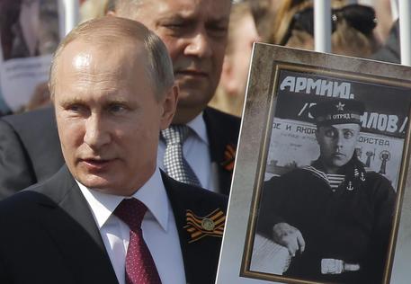 Putin con un ritratto del padre © EPA