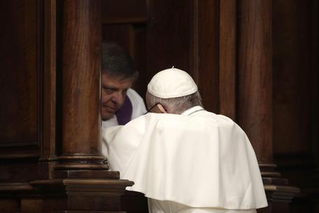 Papa Francesco in ginocchio al confessionale per il sacramento della penitenza © ANSA