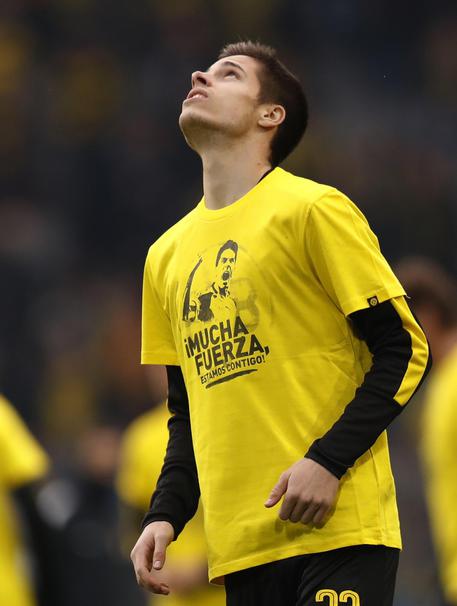 I giocatori del Borussia Dortmund indossano una maglia dedicata al compagno di squadra Marc Bartra, ferito durante l'esplosione davanti al bus della squadra © EPA