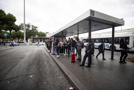 Gente in attesa del bus alla stazione Termini di Roma © ANSA