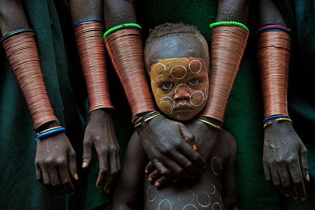 Persone e volti accattivanti - Vince David Nam Lip Lee - I bambini della tribu' Suri, in  Etiopia, sono ancora molto protetti dalle loro famiglie © ANSA