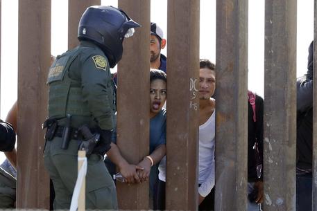 Migranti al muro di confine con gli Usa © AP