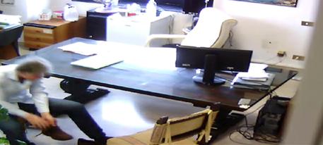 Nell'immagine allegata all'ordinanza Giancarlo Longo effettua una bonifica nel suo ufficio per controllare la presenza di microspie © ANSA