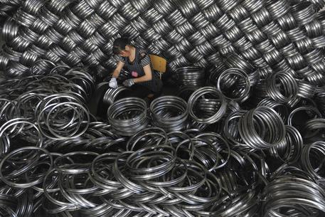 Cina, una operaia a lavoro in una fabbrica © AP