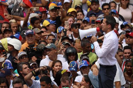 Juan Guaidò parla alla folla col megafono durante la manifestazione contro Maduro © EPA