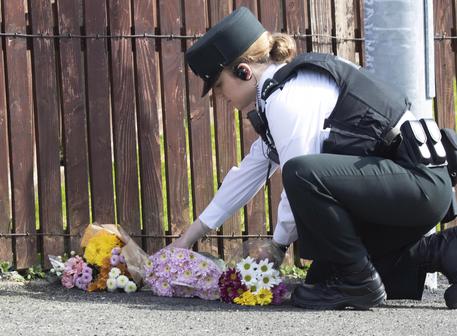 Una poliziotta depone un fiore nel punto in cui è morta Lyra McKee © EPA