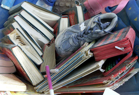 Una scarpa, dei libri e  un pennarello tra le macerie della scuola di San Giuliano di Puglia (Campobasso) crollata a causa  del terremoto (archivio) © ANSA 