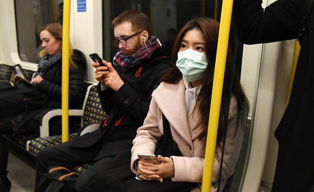 Persone con le mascherine sulla metropolitana a Londra © EPA