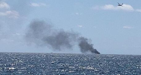 Il fumo causato dall'incendio del barcone © ANSA