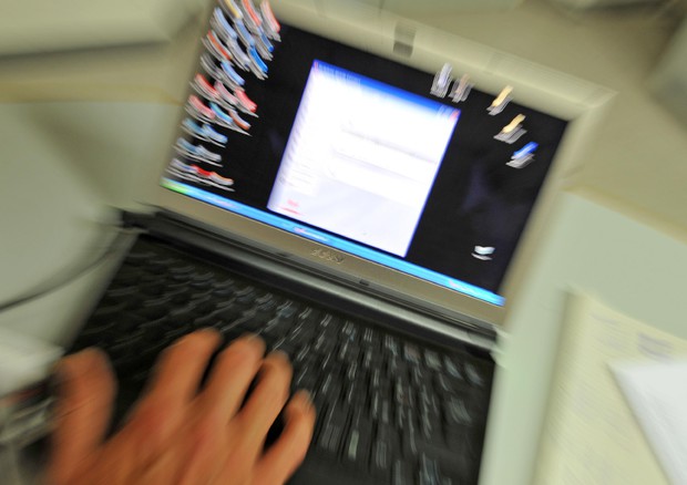 Un uomo utilizza un computer portatile in una foto d'archivio © ANSA